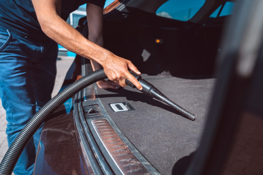 Man vacuuming a trunk
