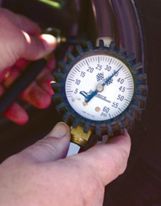 man-using-tire-pressure-guage